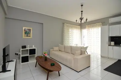 a living room with a white couch and a table at Athenian Riviera Beach front apartment 2 minutes from Tram stop in Athens