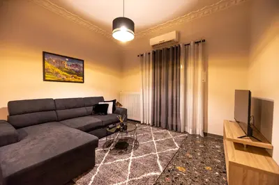 a living room with a couch and a television at STAMOS Apartment airport in Spáta