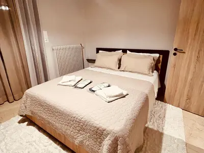 a bedroom with a bed with towels on it at STAMOS Apartment airport in Spáta