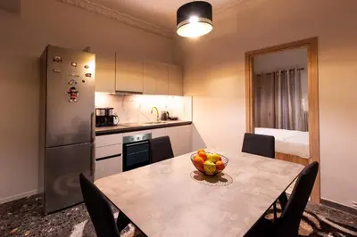 a kitchen with a table with a bowl of fruit on it at STAMOS Apartment airport in Spáta