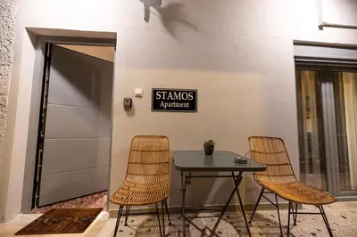 a table with two chairs and a sign on a wall at STAMOS Apartment airport in Spáta
