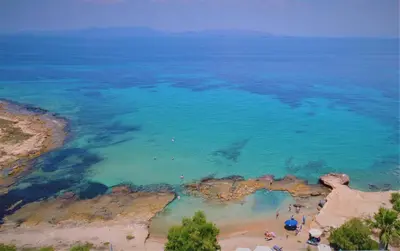an aerial view of a beach with blue water at The Beachhouse Apartments in Vaia