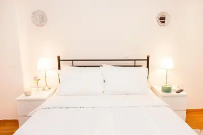 a bedroom with a white bed with two lamps at Anastasia apts Athina in Athens