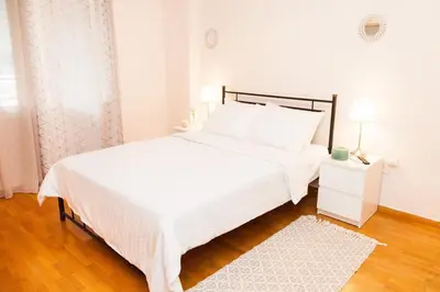 a white bedroom with a large white bed and a white rug at Anastasia apts Athina in Athens
