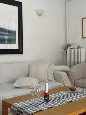 a living room with a couch and two wine glasses on a table at Anastasia apts Athina in Athens