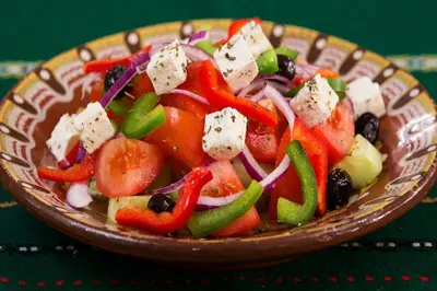 a bowl of salad with vegetables and cheese on a table at Exquisite Athens Apartment 1 Bedroom Apartment Metalicana Balcony in Athens