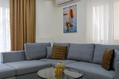 a living room with a blue couch and a glass table at Magnificent Riviera Residence VIPGreece in Athens