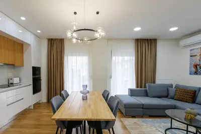 a living room with a table and a blue couch at Magnificent Riviera Residence VIPGreece in Athens