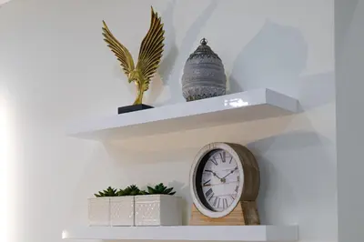 a shelf with a clock and a statue on it at Magnificent Riviera Residence VIPGreece in Athens