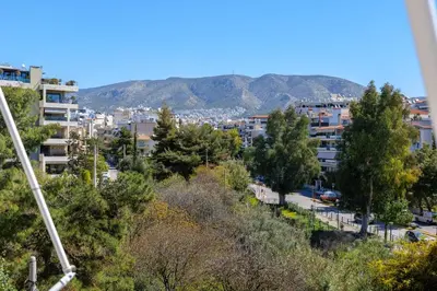 a city with buildings and trees and mountains in the background at Magnificent Riviera Residence VIPGreece in Athens