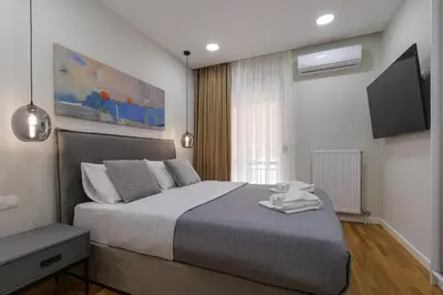 a bedroom with a large bed and a flat screen tv at Magnificent Riviera Residence VIPGreece in Athens