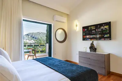 a bedroom with a bed and a large window at Vouliagmeni Athenian Riviera Villa in Athens