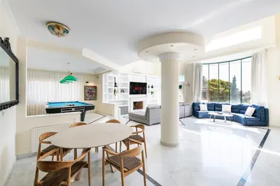 a living room with a table and chairs at Vouliagmeni Athenian Riviera Villa in Athens