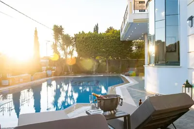 a swimming pool with a table with a bucket on it at Vouliagmeni Athenian Riviera Villa in Athens