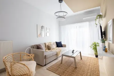 a living room with a couch and a table at Santorini 2-Bedroom Apartment in Nea Smyrni in Athens