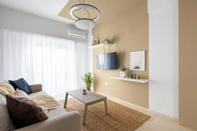 a living room with a couch and a table at Santorini 2-Bedroom Apartment in Nea Smyrni in Athens