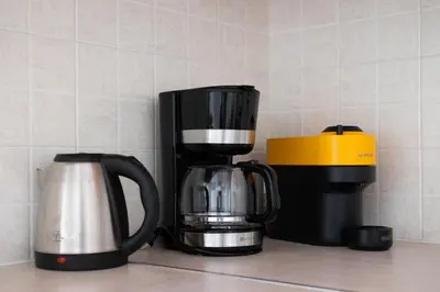 two coffee pots and a coffee maker on a counter at Santorini 2-Bedroom Apartment in Nea Smyrni in Athens