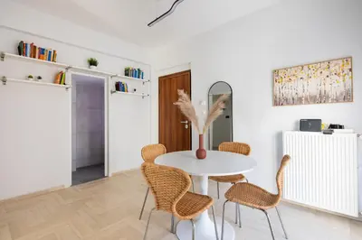 a white dining room with a white table and chairs at Santorini 2-Bedroom Apartment in Nea Smyrni in Athens