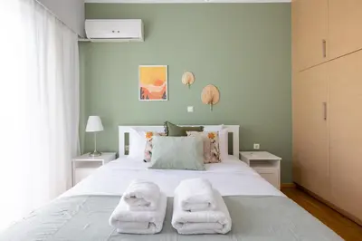 a bedroom with a large white bed with towels on it at Santorini 2-Bedroom Apartment in Nea Smyrni in Athens