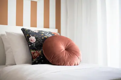a pillow sitting on top of a bed with a floral pillow at Santorini 2-Bedroom Apartment in Nea Smyrni in Athens