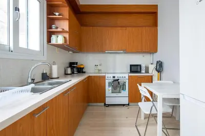 a kitchen with wooden cabinets and a sink and a stove at Santorini 2-Bedroom Apartment in Nea Smyrni in Athens