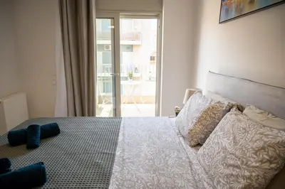 a bedroom with a bed with a large window at Elegant and cozy flat near Pagrati region (D1) in Athens