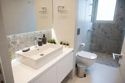 a white bathroom with a sink and a toilet at Elegant and cozy flat near Pagrati region (D1) in Athens