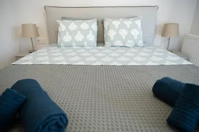 a bed with blue and white pillows on it at Classy and stylish flat near Pagrati region (D2) in Athens