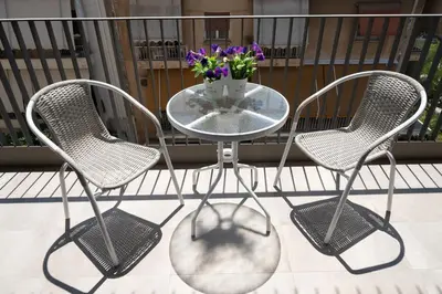 two chairs and a glass table with a vase of flowers at Classy and stylish flat near Pagrati region (D2) in Athens