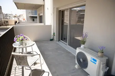 a balcony with a washing machine and a table and chairs at Classy and stylish flat near Pagrati region (D2) in Athens