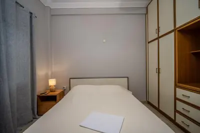 a bedroom with a white bed and a dresser and a lamp at ANGEL , Luxury 2BD apartment next to the Beach in Athens