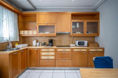 a kitchen with wooden cabinets and a microwave at ANGEL , Luxury 2BD apartment next to the Beach in Athens