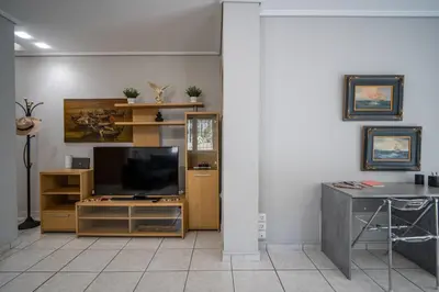 a living room with a television and a table at ANGEL , Luxury 2BD apartment next to the Beach in Athens