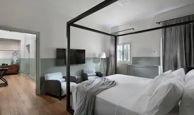 a bedroom with a bed and a tv and a chair at Stunning Athens Apartment 1 Bedroom Apartment Juvia Athinaidos in Athens