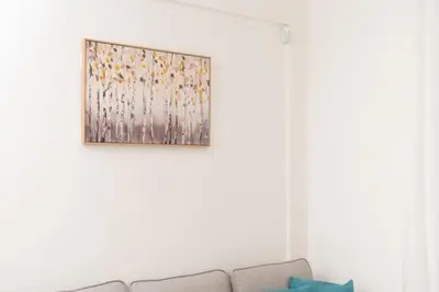a painting hanging on a wall above a couch at Zografou House Living by 8essentially in Athens
