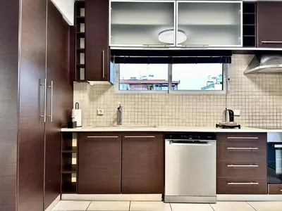 a kitchen with brown cabinets and a white dishwasher at Elaia Luxury Selection Amber in Athens