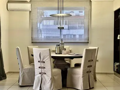a dining room with a table and chairs and a window at Elaia Luxury Selection Amber in Athens