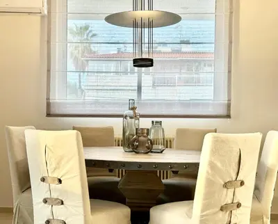 a dining room with a table with chairs and a chandelier at Elaia Luxury Selection Amber in Athens
