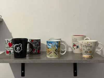 a shelf with four coffee mugs on it at Guest house Elina in Kalívia Thorikoú