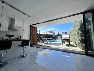 a kitchen and living room with a large sliding glass door at One Bedroom Pool House by Olivujoj in Anavissos