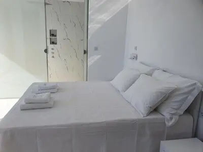 a white bed with two towels on top of it at One Bedroom Pool House by Olivujoj in Anavissos