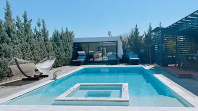 a swimming pool with two chairs and a house at One Bedroom Pool House by Olivujoj in Anavissos