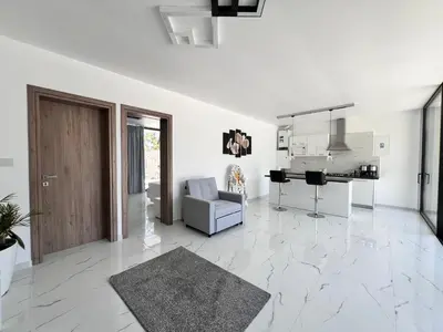 a white living room with a door and a couch at One Bedroom Pool House by Olivujoj in Anavissos