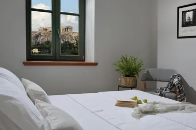 a bedroom with a bed and a window with a view at Charming Athens Villa 1 Bedroom Villa Kyoraku Panoramic Acropolis View in Athens