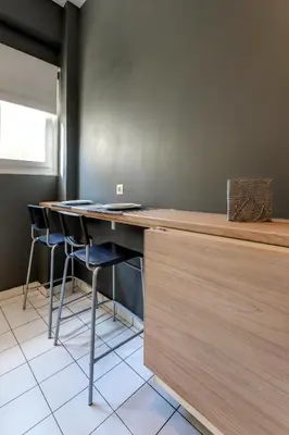 a kitchen with a counter with stools in a room at Modern Faliro Flat in Athens