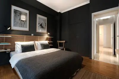 a bedroom with a large bed with black walls at Modern Faliro Flat in Athens