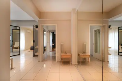 a large room with a glass corridor with chairs and tables at Modern Faliro Flat in Athens