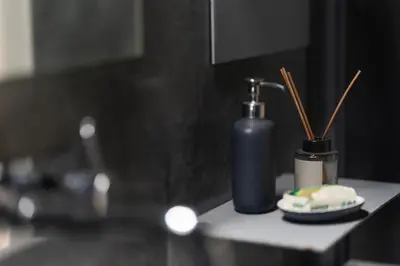 a bathroom counter with a bottle of soap and a toothbrush at Modern Faliro Flat in Athens