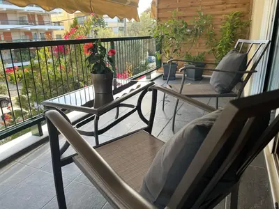 a patio with two chairs and a table on a balcony at glyfada luxury home in Athens