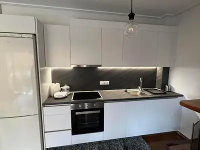 a kitchen with white cabinets and a stove top oven at glyfada luxury home in Athens